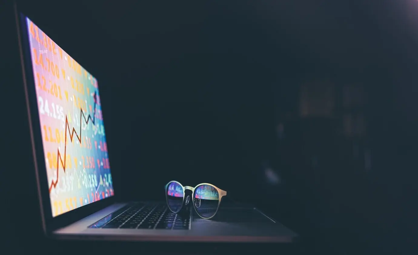 График и финансовые данные фондового рынка на электронном табло на экране ноутбука.